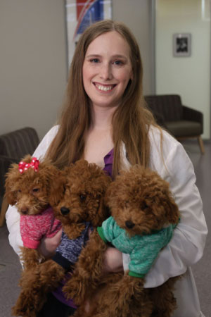 Dr. Upchurch holding three fuzzy puppies