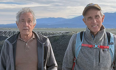 Portrait of Dr. John and Jim Schumacher in front of mountains