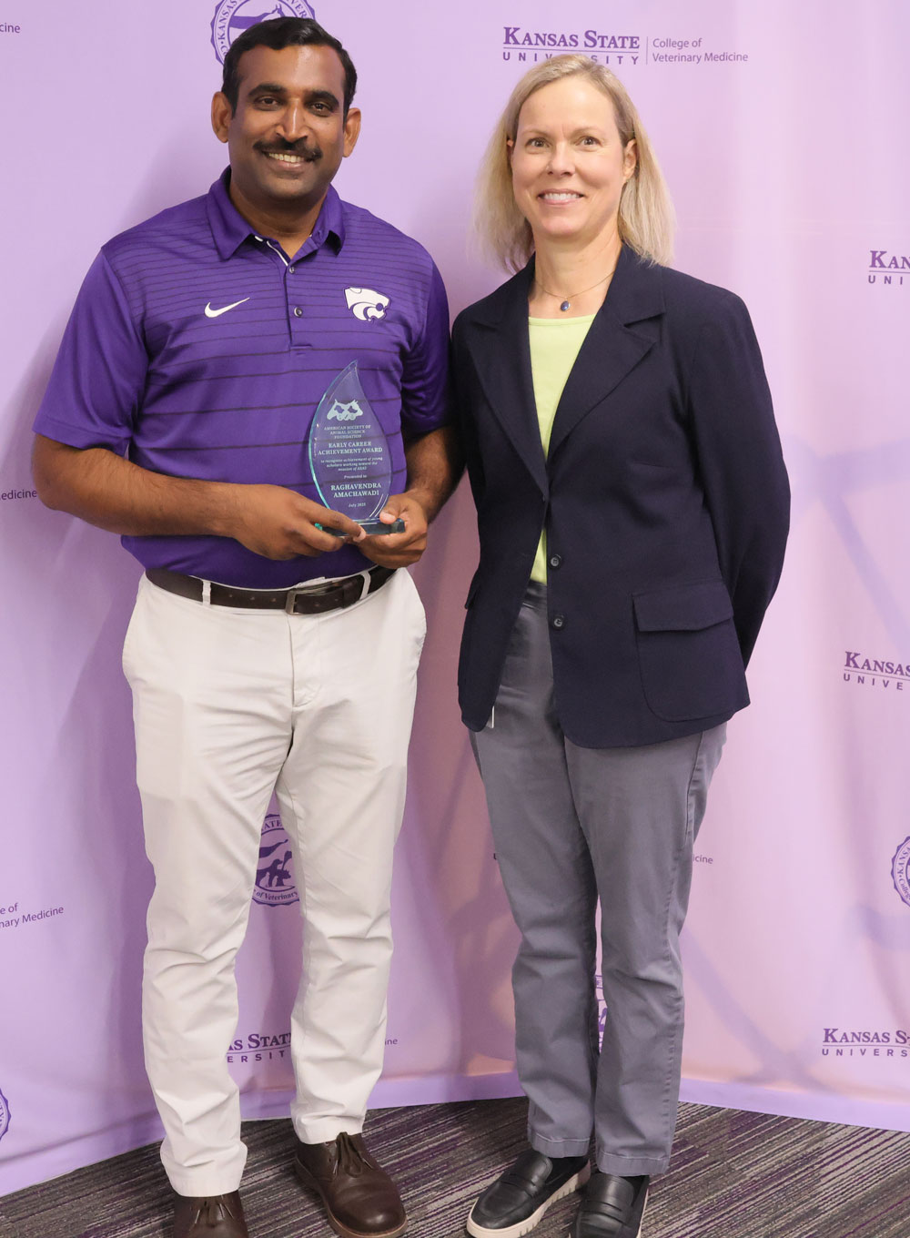 Dr. amachawadi and Dr. Davis standing in front of a KSU vet med step and repeat of a 