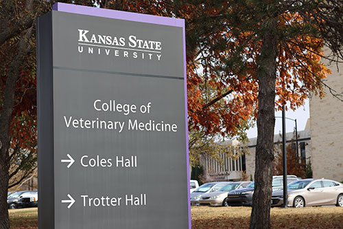 Black sign stands in front of Vet Med buildings.