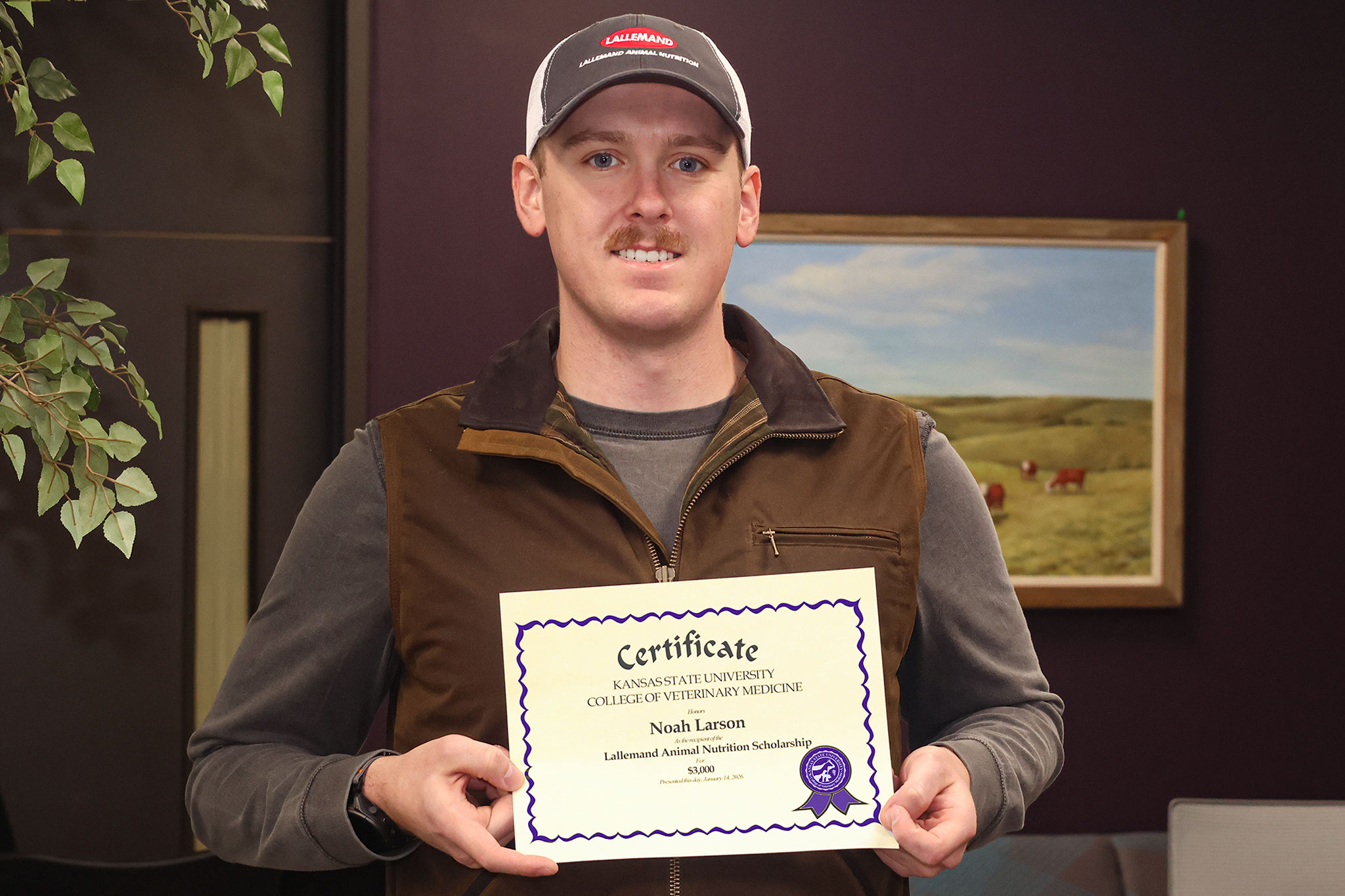 Second-year student Noah Larson holds a certificate for the LAN scholarship