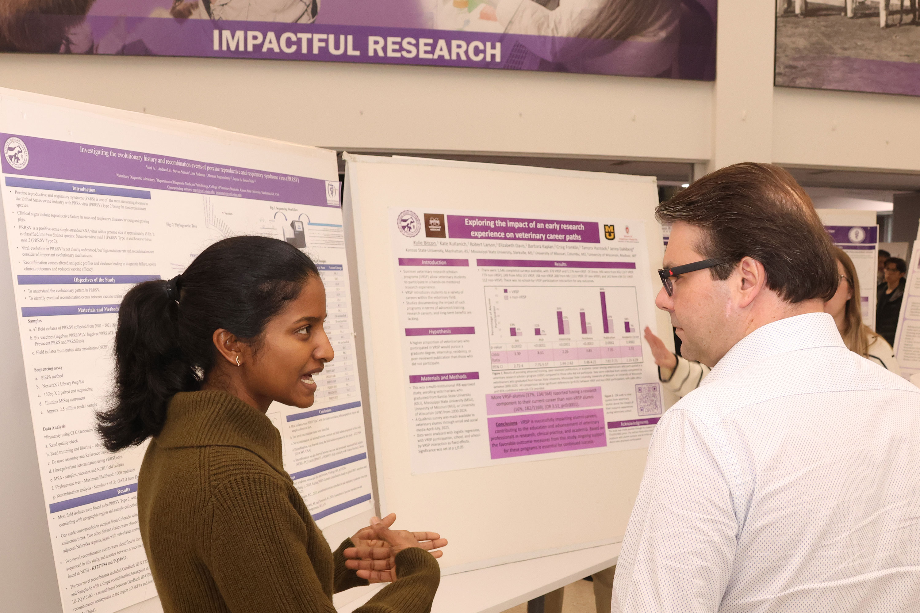 Student explains research project at poster presentation