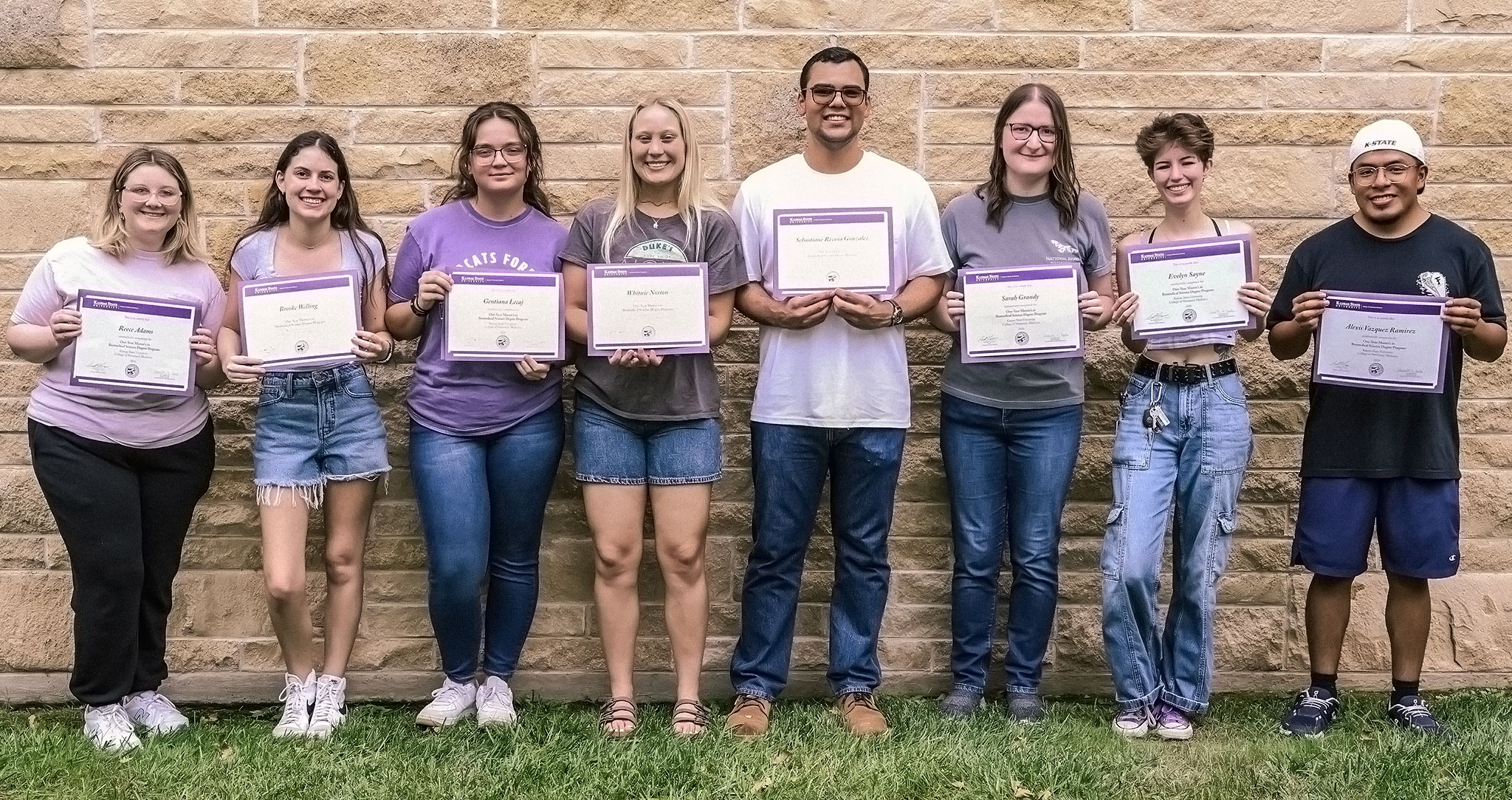 A group of eight students holding certificates