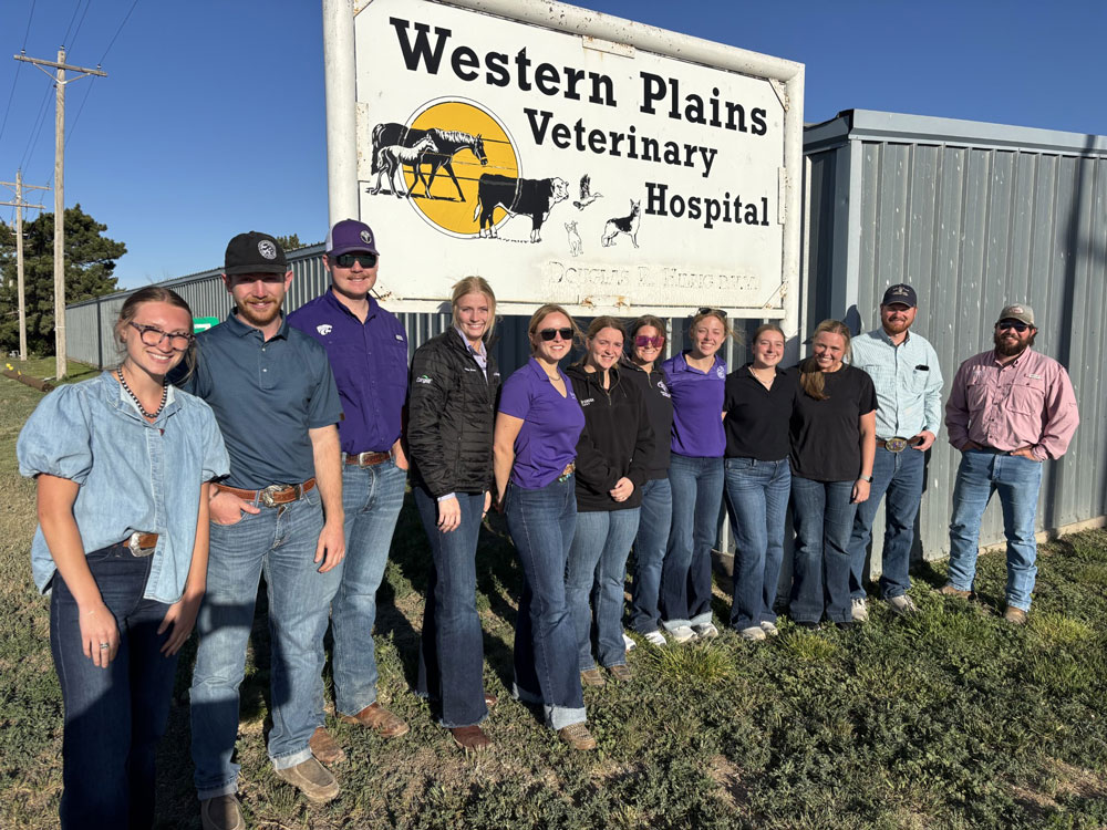 Scholars standing in front of the Western Plains Veterinary Hospital.