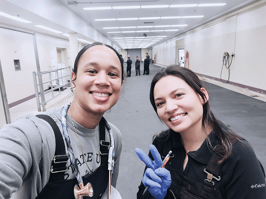Two people are smiling happily in an empty hallway, creating a warm and inviting atmosphere.