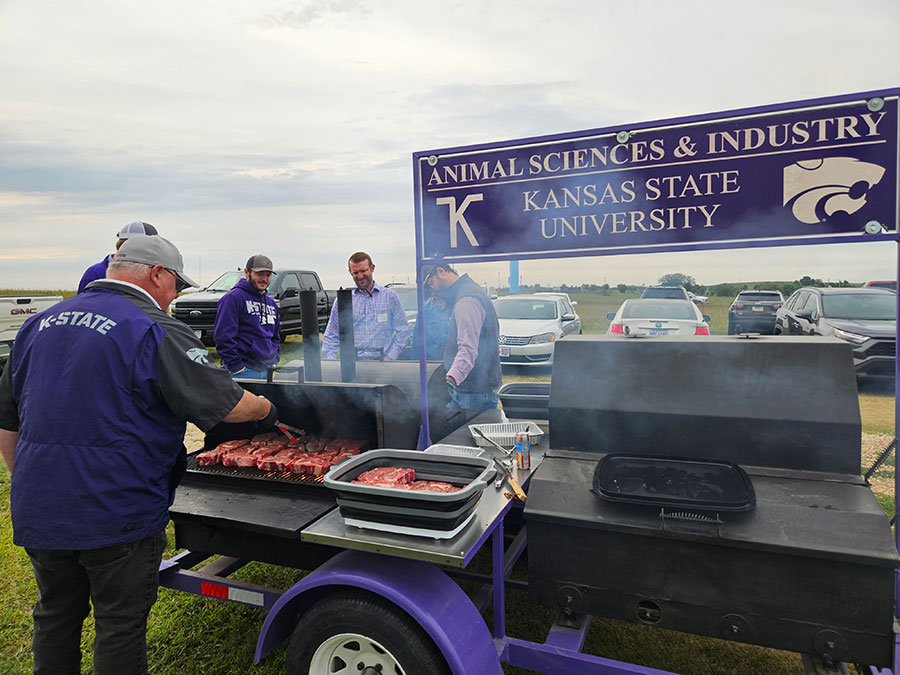 Students gather around a barbecue grill