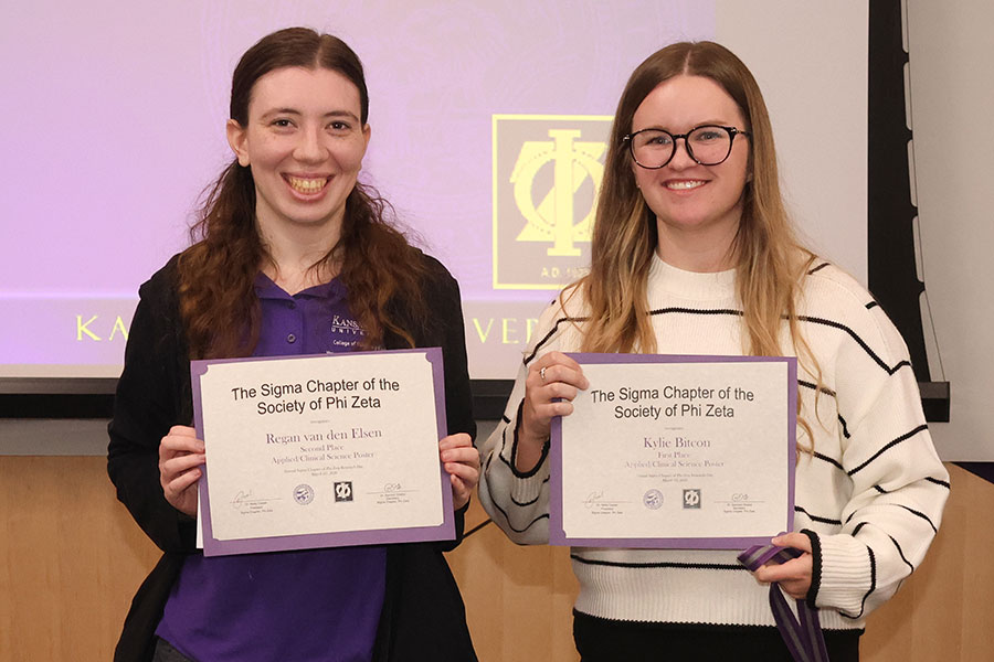 Two students hold certificates