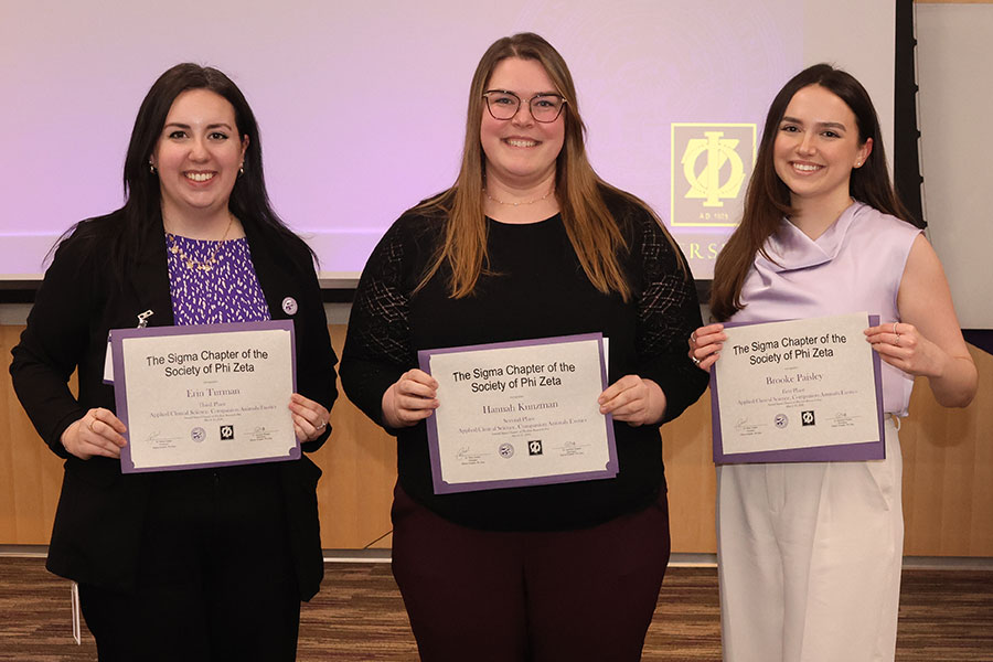 Three students hold certificates