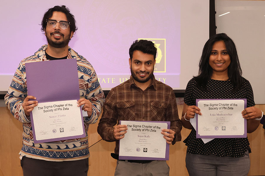 Three students hold certificates