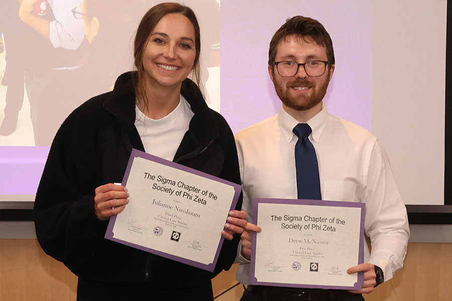 Two students hold certificates