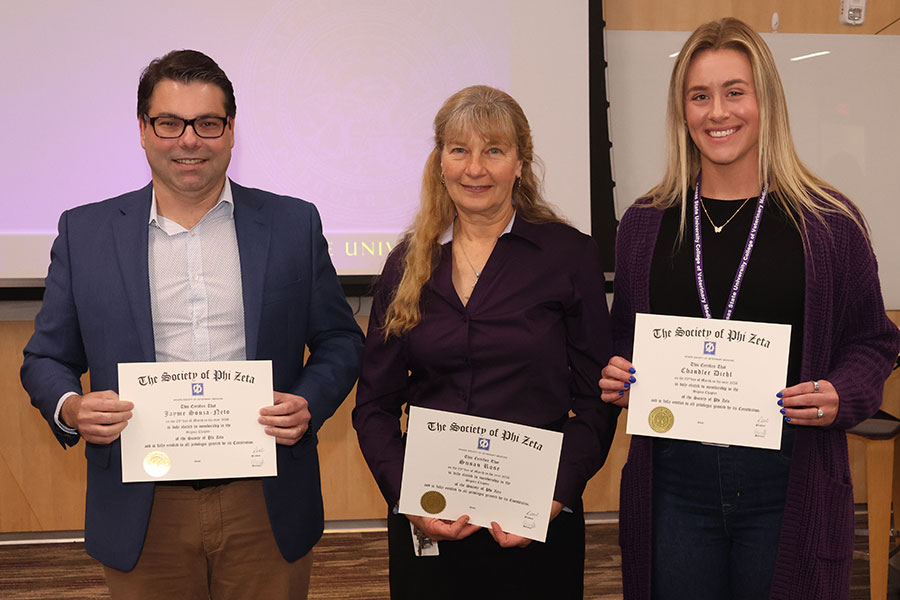 Three people hold certificates