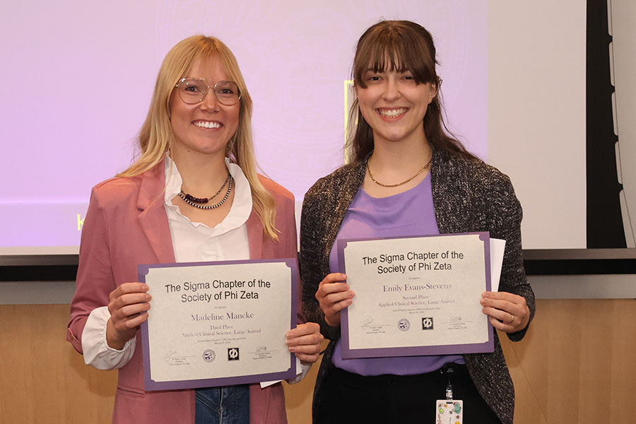 Two students hold certificates