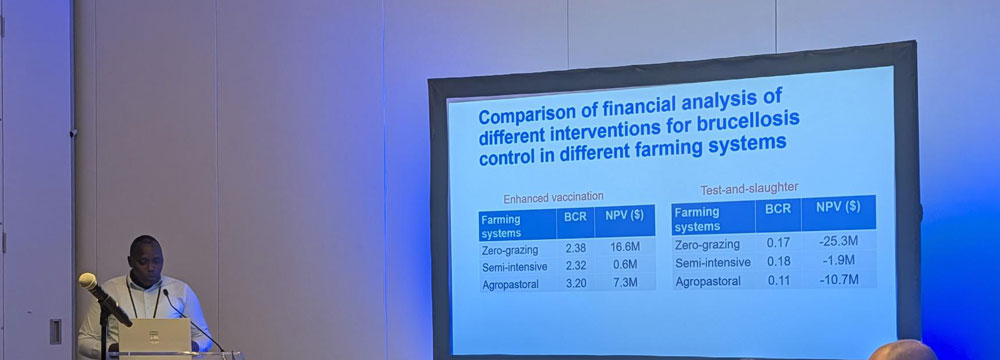 David K at podium in corner with display slide showing next to him.