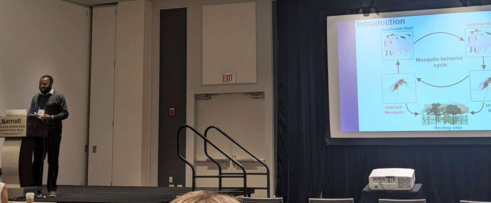 Stephen at podium with slide on display next to him.